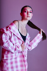 Young beautiful woman plaid blazer fashion posing luxury pink background unaltered