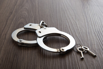 Police metal handcuffs on dark wooden background
