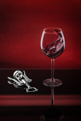glass goblet of moving red wine on a red background