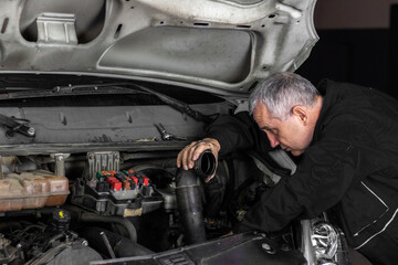 Fototapeta na wymiar Senior experienced mechanic repairing a car