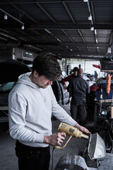 Car service worker repairs restores car