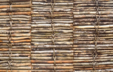 Wicker fence from dry branches, background. Eco-friendly fencing material.