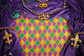 Frame of Mardi Gras Mask and colorful Mardi Gras Beads on diamond shaped background