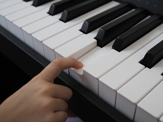 Close-up of a child's hand playing the piano . Favorite classical music. musical instruments for...