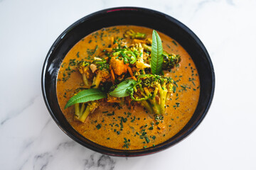 vegan yellow curry with broccoli and tofu cubes, healthy plant-based food