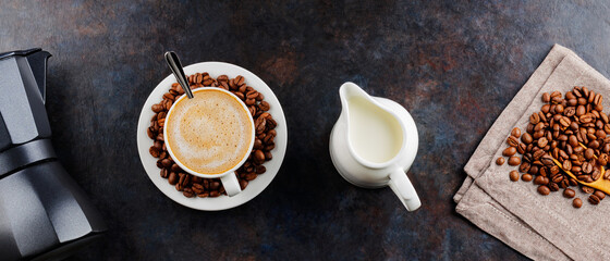 Cup of coffee and coffee beans on a dark background. Ingredients for making coffee with milk. Top...