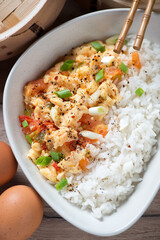 Close-up of chinese-style scrambled eggs with tomatoes and white rice, vertical shot, elevated view