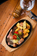 frying pan with fried sausage, potatoes and egg