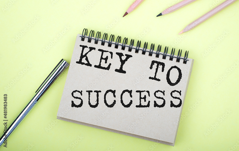 Poster key to success text on notepad on yellow background