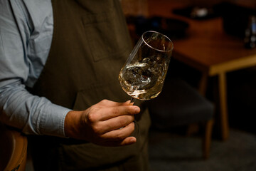 view of male hand with beautiful wine glass with a splashed drink