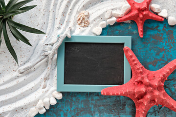 Sand and sea background on turquoise blue board and red sea starfish. Natural exotic plant. Flat...