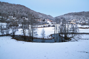 Kleines Tal mit Bach und einer dünnen Schneedecke