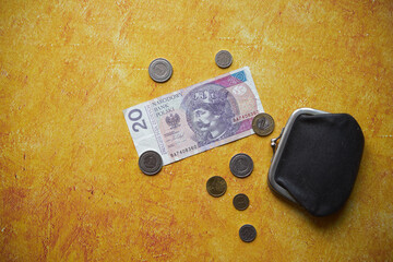 pieniądze ,monety i czarna portmonetka na żółtym tle,polski złoty	
