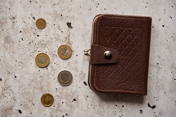 monety i brązowy portfel na betonowym stole,polski złoty	