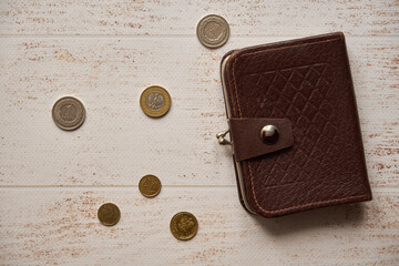 monety i brązowy portfel na drewnianym stole,polski złoty	