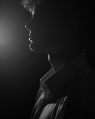 Profile back-light man portrait in white shirt in black and white