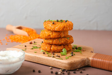 Board with tasty lentil cutlets on table