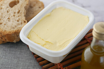 fresh butter in a container with bread on white background  - obrazy, fototapety, plakaty