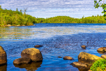 Beautiful landscape with lake and stone boulders in northern forest on summer sunny day. Amazing scenery with pond among woodland. Solovetsky island or Solovki in Arkhangelsk region, Russia