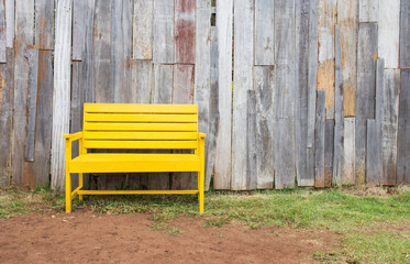 New yellow chair with old wood wall