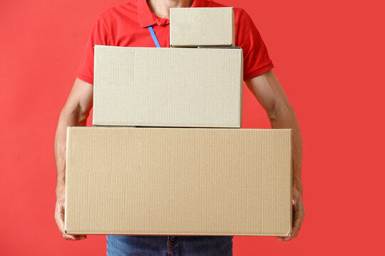 Male courier with parcels on color background