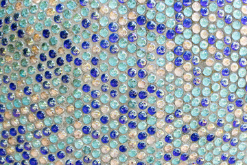 Penny round mosaic tiles. Round circle tile. Glass abstract round multicolor mosaic pattern. Mosaic background of round glass blue turquoise balls in wall. Colored mosaic square for background texture