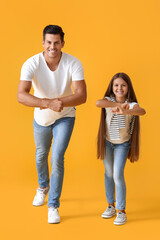 Happy dancing man and his daughter on color background