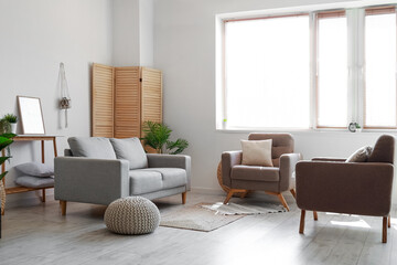 Interior of modern living room with comfortable armchairs and sofa