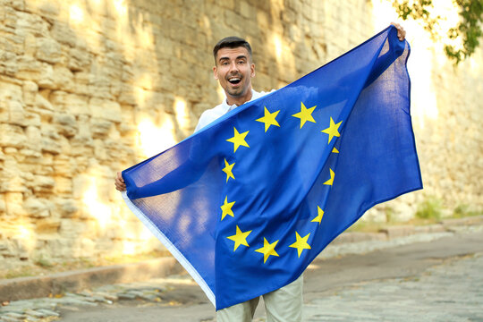 Young man with flag of European Union outdoors
