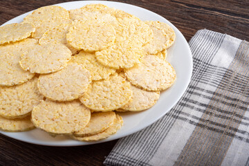 Close up a plate with cornbread on a wooden table.