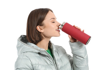 Beautiful young woman drinking hot tea from thermos on white background