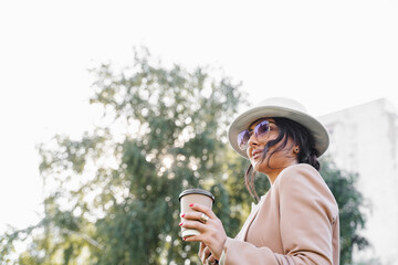 Close-up portrait of business lady is drinking coffee outdoor in the park.