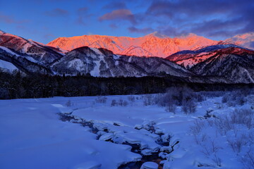 Obraz premium モルゲンロートに輝く冬の白馬三山と松川（白馬大橋より）