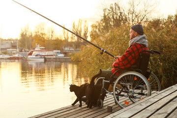 Man in wheelchair fishing on river