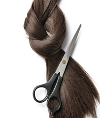 Dark brown hair strand for donation with scissors on white background