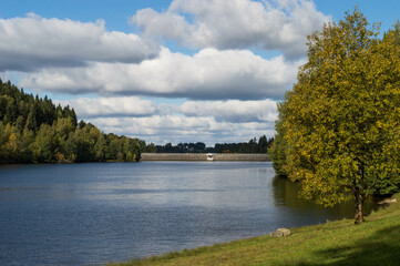 Fototapeta na wymiar dam with blue sky and clouds on a beautiful day in fall
