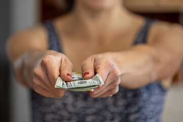 Closeup of woman hand giving money.