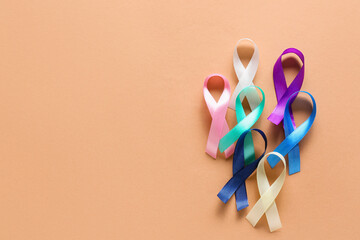 Different awareness ribbons on beige background. World Cancer Day