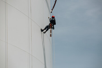 Male workers control rope down height tank rope access inspection of thickness shell plate storage tank