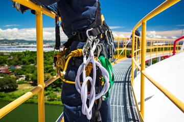 Closeup male worker standing on tank male worker height roof tank knot carabiner rope access