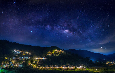 Milky Way galaxy on a village in a valley in northern Thailand. Long exposure photograph, with grain.Image contain certain grain or noise and soft focus.