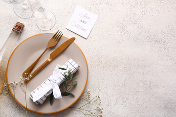 Beautiful table setting with wedding invitation on light background