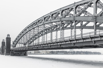 Winter cityscape of metal bridge over frozen river, St. Petersburg, Russia