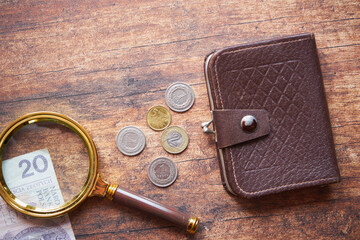monety, brązowy portfel i lupa na drewnianym stole,polski złoty  - obrazy, fototapety, plakaty
