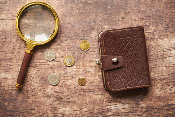 monety, brązowy portfel i lupa na drewnianym stole,polski złoty 