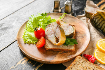 Plate with pieces of smoked mackerel fish and bread on table