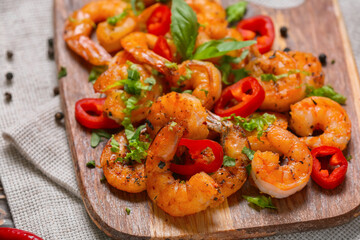 Wooden board of tasty shrimp tails on table
