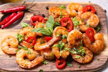 Wooden board of tasty shrimp tails on table