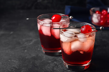 Glasses of tasty Manhattan cocktail on black background