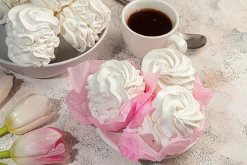 Handmade marshmallows on a light background in the form of roses, hydrangeas and tulips. There are flowers nearby. Women's day, Valentine's day.